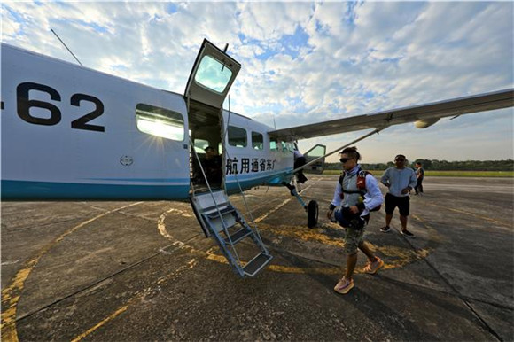 9月26日，参加跳伞项目体验的游客与专业教练一起登上飞机。通讯员 熊伟 摄