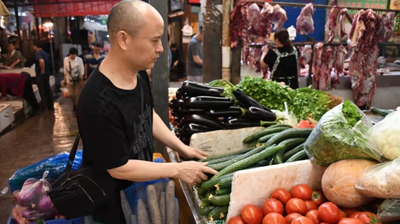 杨大富在市场选购食材。受访者供图 华龙网发