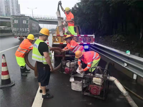 8-7月12日9时左右，应急抢险人员对东环路段边沟积水进行抽排。市市政设施运行保障中心供图 华龙网发