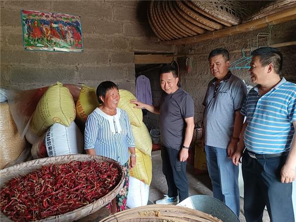 杨元蓉（左一）向驻村干部谈起丰收喜笑颜开。特约通讯员 蒋文友 摄