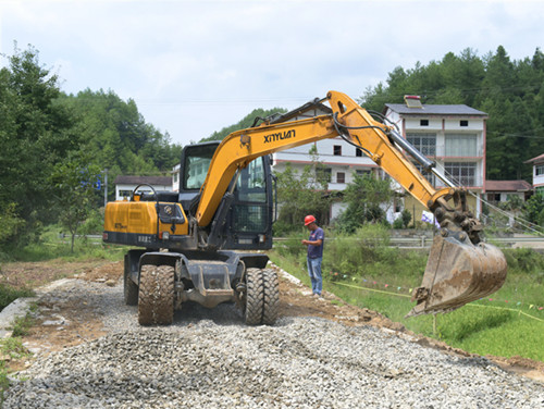 施工人员在新建农村公路上铺设石子。特约通讯员 隆太良 摄