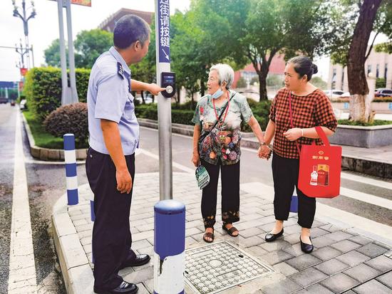 民警为市民讲解自助式过街信号装置使用方法。通讯员 刘爽 供图