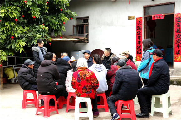 荣昌区万灵镇志愿者和村里留守老人围坐一起共话新年好。荣昌区委宣传部供图 华龙网发