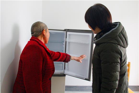 2喻崇琼向红梅书记展示已购买的新冰箱。通讯员 龚晓梅 摄