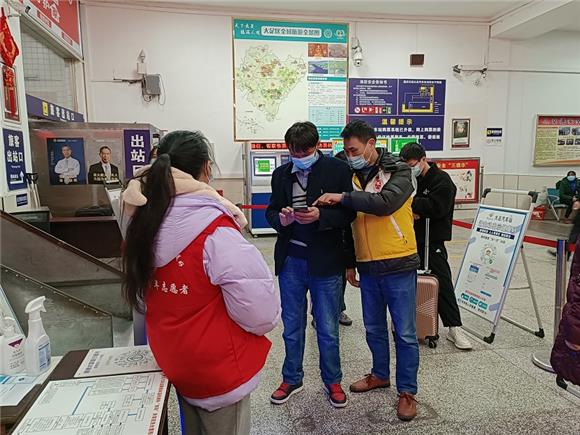 1大足交通志愿者在大足汽车站安检处为乘客作出行码提示。通讯员 王弟洪 摄