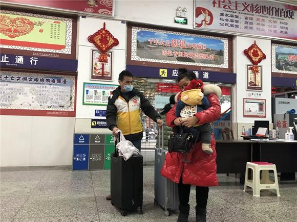 2大足交通志愿者在大足汽车站安检处为乘客提行李箱。通讯员 王弟洪 摄