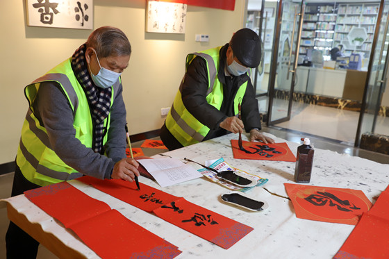 1龙塔书画协会的文化志愿者们在街道文化中心综合楼书画室现场书写春联和福字。通讯员 夏雪晗 摄