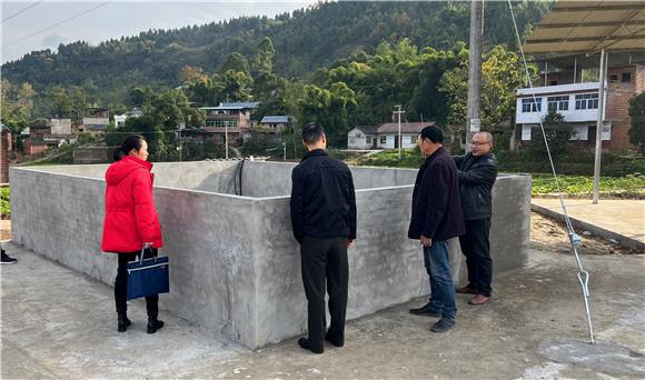纪委干部检查蓄水池修建质量。通讯员  赵七雄 摄