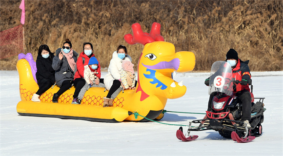1月8日，在北京国际鲜花港冰雪嘉年华现场，游客体验“雪地龙舟”项目。新华社记者 任超 摄