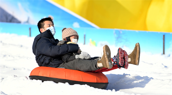 1月8日，在北京国际鲜花港冰雪嘉年华现场，游客们体验“雪圈冲浪”项目。新华社记者 任超 摄