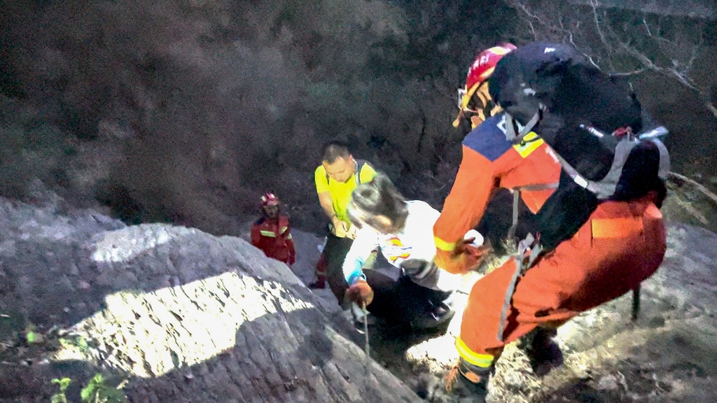 3返回途中，消防员帮助女被困者爬山。重庆涪陵消防供图