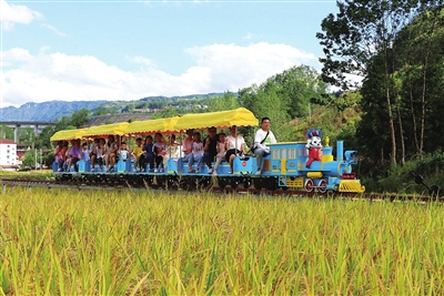 游客坐着葫芦娃小火车欣赏金秋美景。记者 隆太良 通讯员 杨花 摄