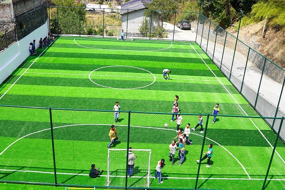 孩子们在五人制标准足球场内踢球。通讯员 黎明 摄