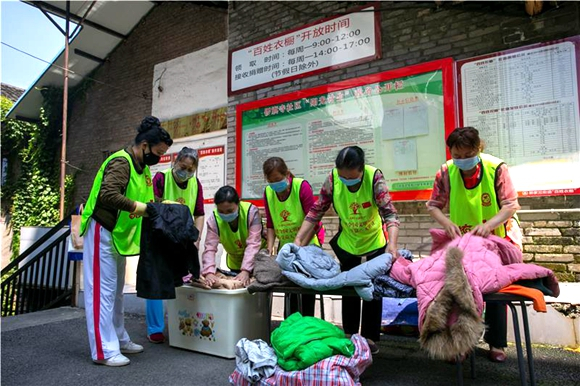 “百姓衣橱”志愿者正在整理收集到的衣服。江北区委宣传部供图 华龙网发