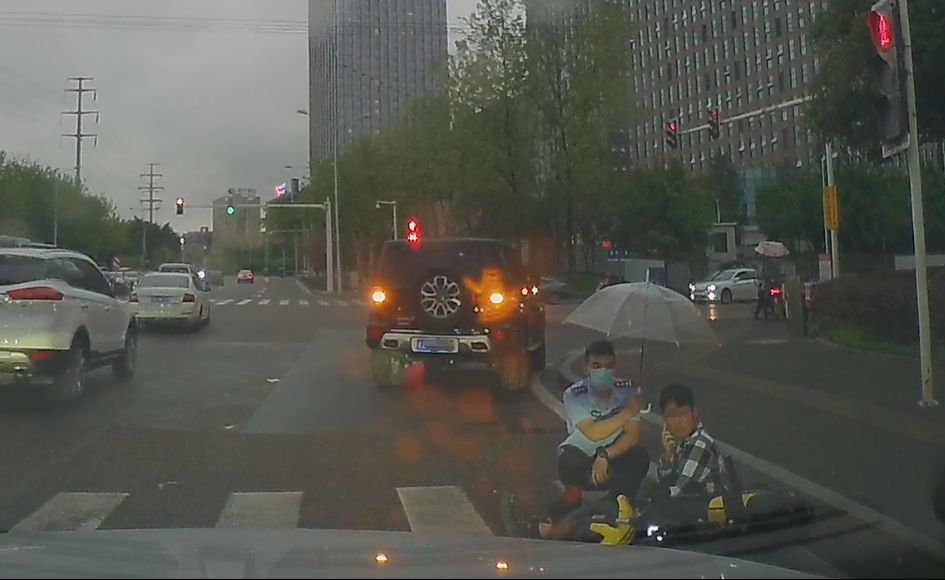 2民警撑伞给小蒋挡雨。重庆沙坪坝警方供图