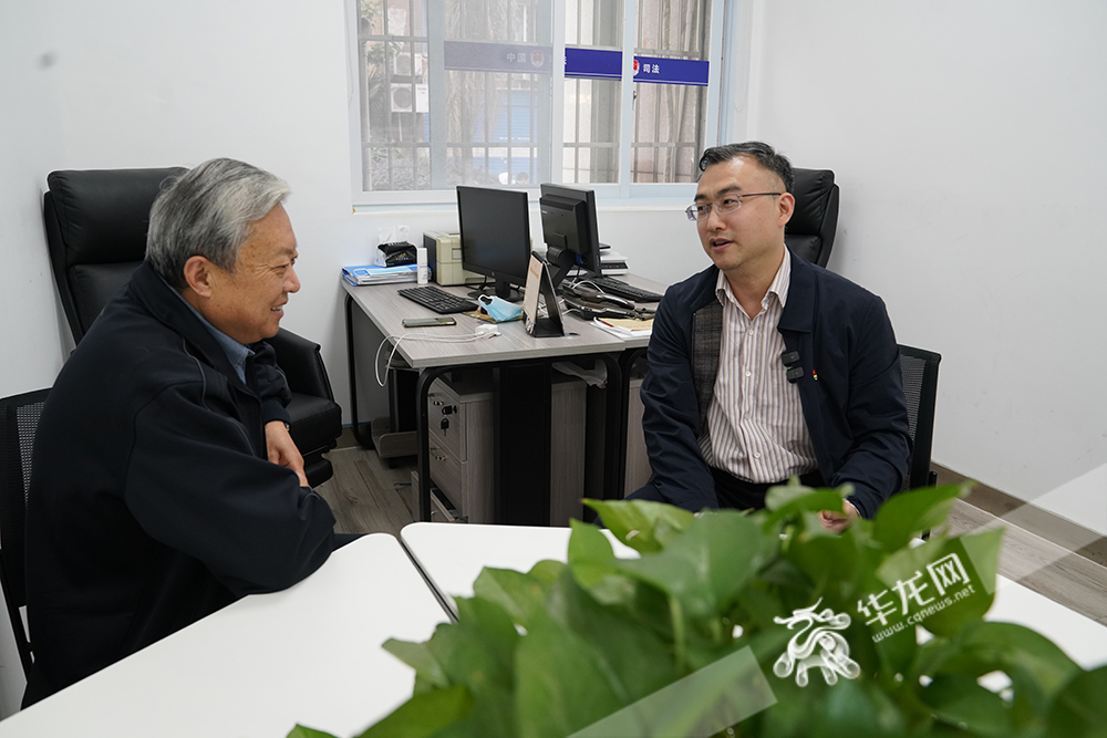 杨懿（右）和70岁的人民调解员陈和初聊调解工作。华龙网-新重庆客户端记者 陈洋摄