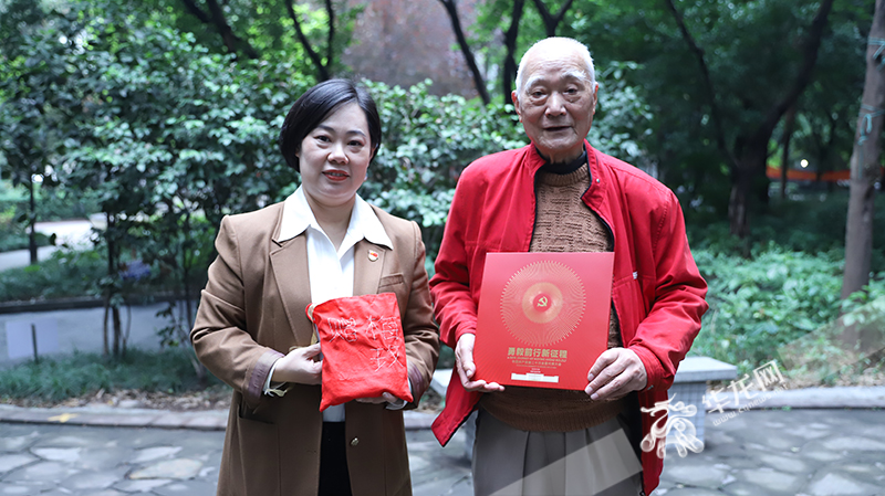 老党员艾远兴和党的二十大代表梅玫展示她们互赠的“礼物”。华龙网-新重庆客户端 记者 陈洋摄