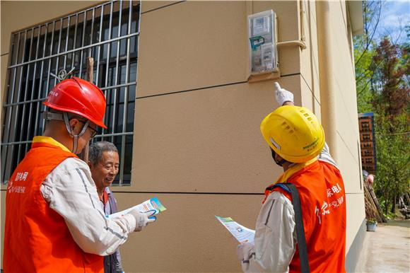 电网员工为农户讲解漏电保护器知识。通讯员 刘远平  摄