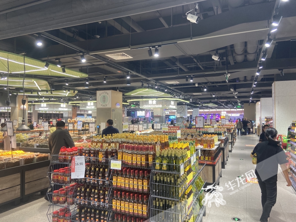 煊超市空港店，市民正有序选购，工作人员忙于补货。