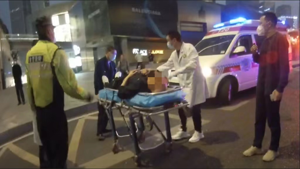 2男子被抬上救护车，送医治疗。重庆江北警方供图