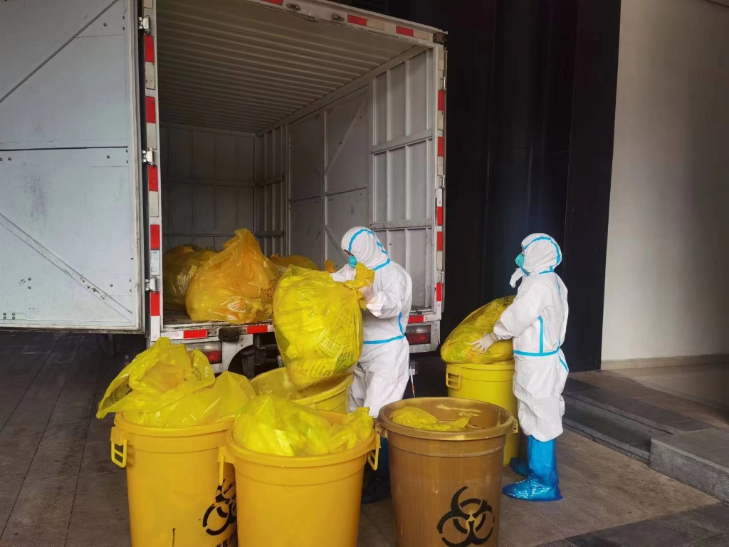 工作人员正对大渡口隔离酒店内产生的医疗废物进行处置转运。重庆市生态环境局供图