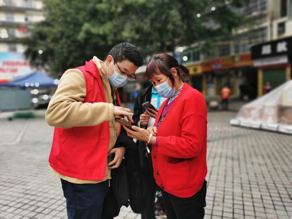 王沁协助居民查看健康码和核酸情况。巫溪县委宣传部供图 华龙网发