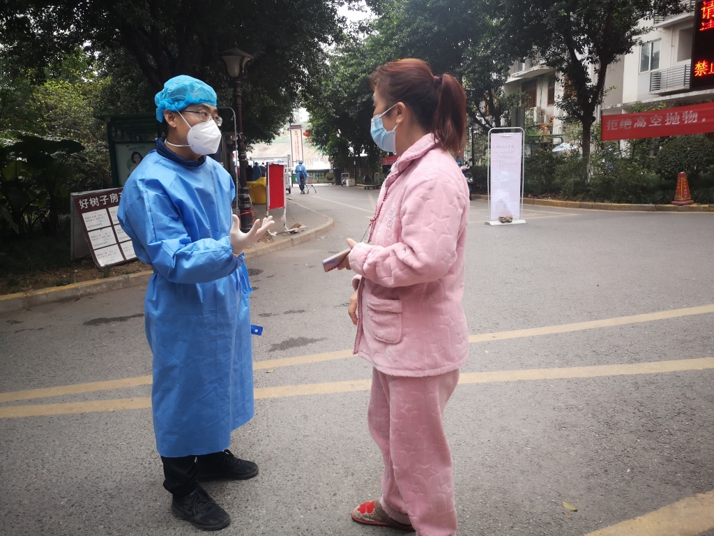 王鑫向居民耐心讲解防疫政策。受访者供图