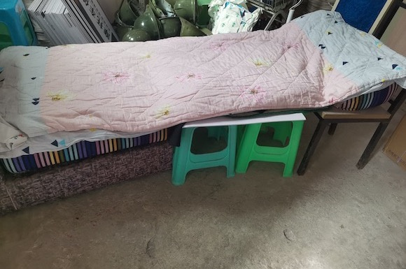 四根板凳、废弃单人沙发拼成的简易床。受访者供图 华龙网发