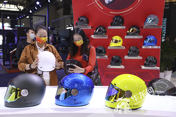 市民选购试戴摩托车头盔。华龙网-新重庆客户端 首席记者 李文科 摄