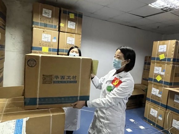 樊银凤与同事一起搬运防疫物资。潼南区委宣传部供图  华龙网发