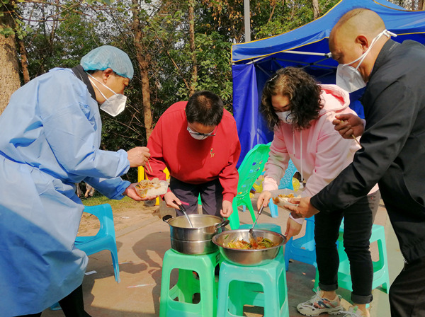 云朝霞（右二）正在为工作人员乘萝卜排骨汤。通讯员 李芳 摄