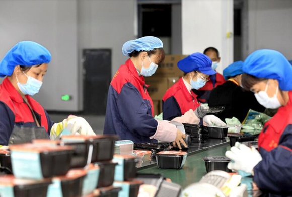 梁平奇爽食品有限公司生产车间，工人在包装生产好的预制菜产品。
