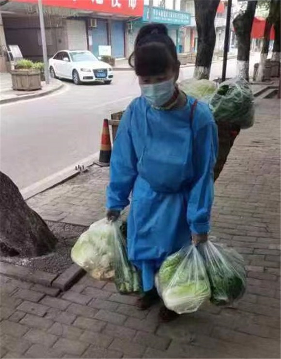 王家街道文化志愿者为楼栋居民送新鲜蔬菜。王家街道办事处供图 华龙网发