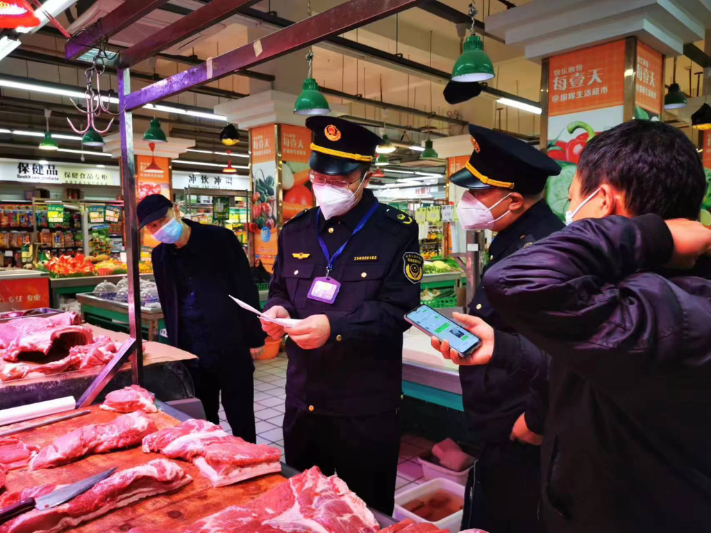 执法人员在超市检查民生物资价格。梁平区市场监管局供图