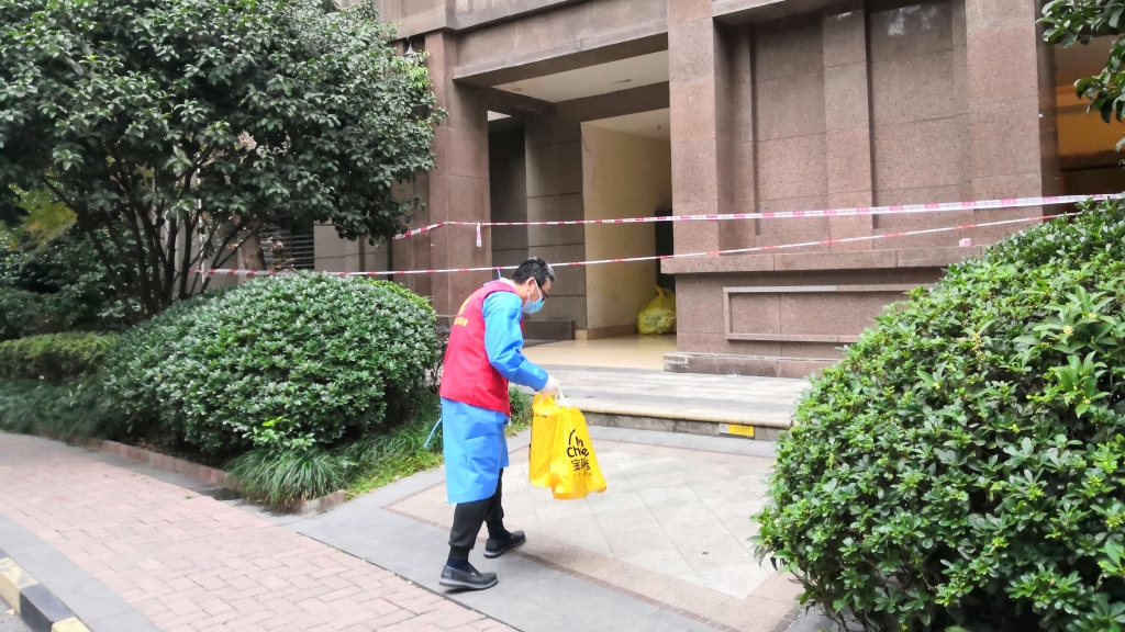 志愿者为封控楼栋居民送物品。受访者供图