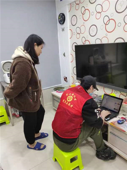 志愿者到居民家里修电脑 。龙山街道办事处供图 华龙网发
