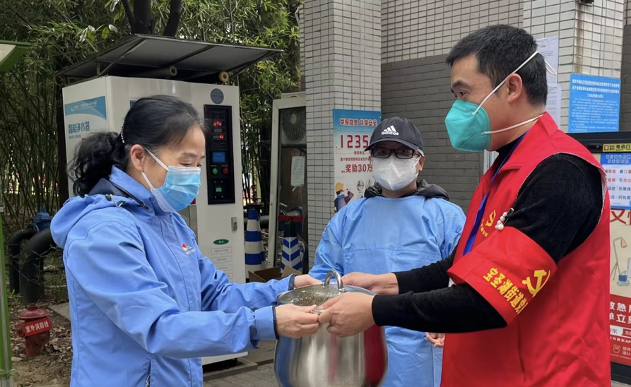 小区居民余晓丽（左一）给社区疫情防控一线的志愿者送鸡汤。受访人 供图
