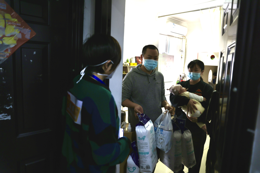 “重庆妈妈”杨霞将急需的奶粉、尿不湿等婴儿用品送往居民家中。通讯员 谢尚弟 摄