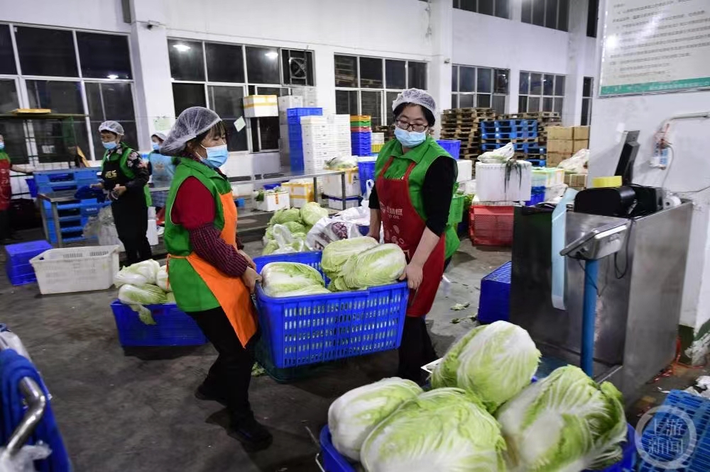 分拣仓的员工准备把食材装箱。受访单位供图