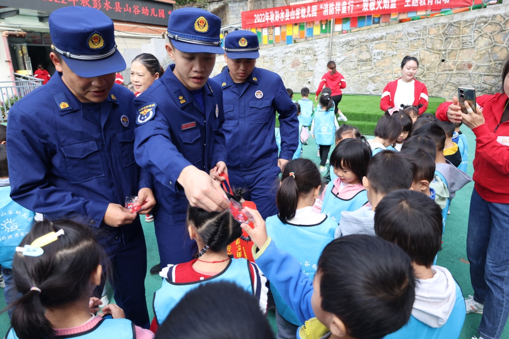 消防员向小朋友们发放小礼品。彭水县消防救援大队供图 华龙网发