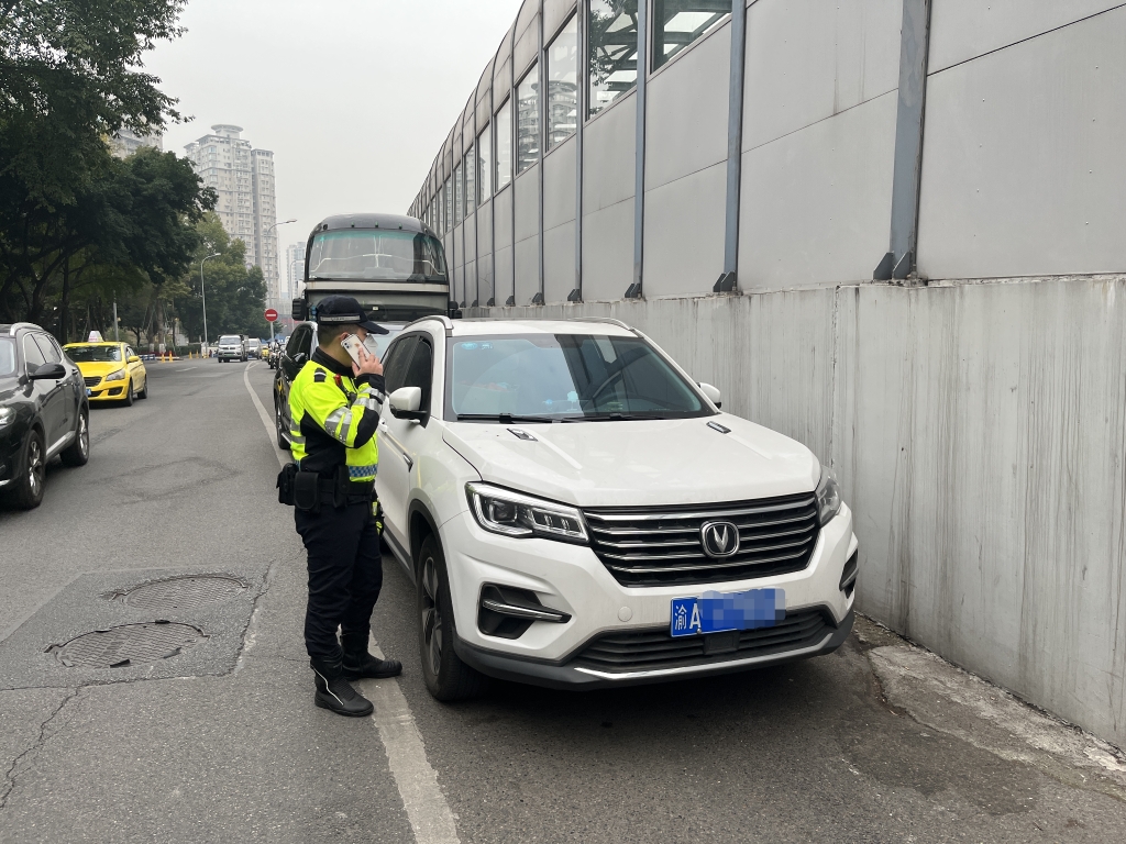 1民警通知违停车辆的主人前来挪车。重庆沙坪坝警方供图