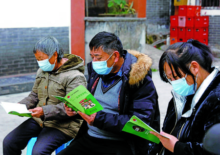 村民们仔细阅读法律知识读本。记者 吴文艺 摄