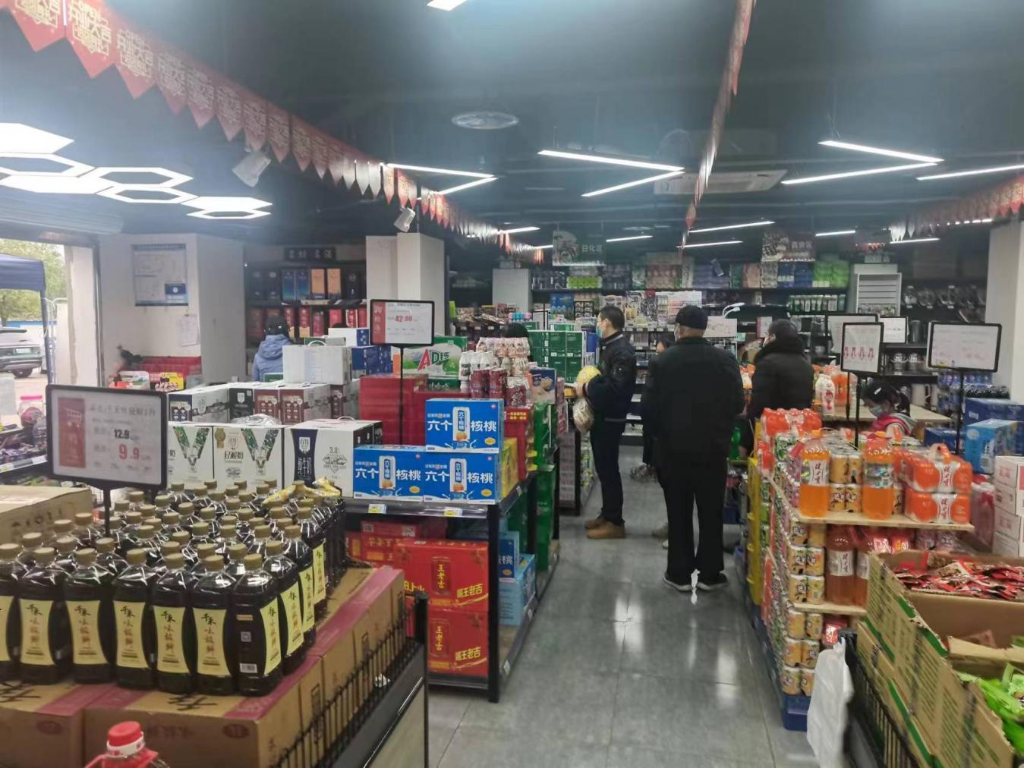 12月2日，含谷镇裕安佳园小区外的超市恢复正常经营，居民正在挑选货物。含谷镇供图