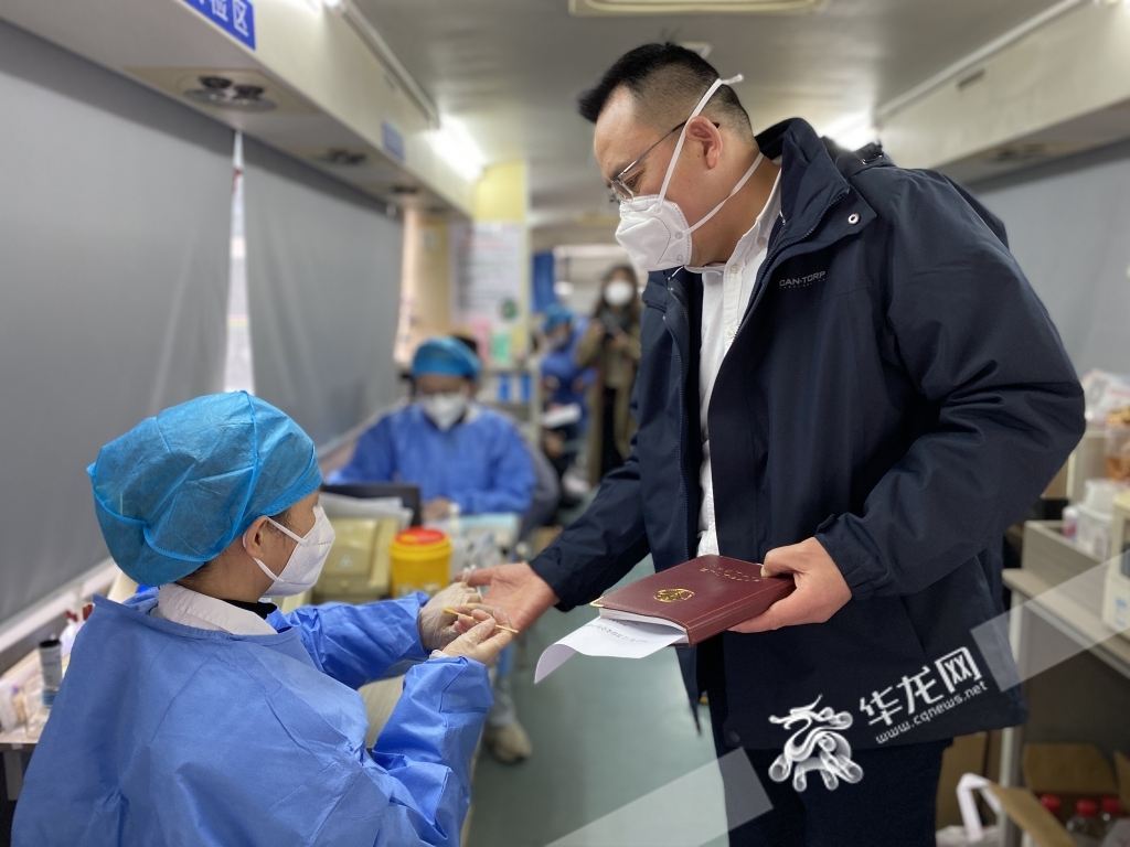 12月22日，重庆市卫生健康委工作人员（右）走上献血车。华龙网-新重庆客户端记者 刘钊 摄