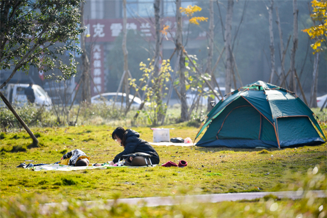 市民带着孩子来到彩云湖搭帐篷晒太阳。九龙坡报记者 冉冉 摄