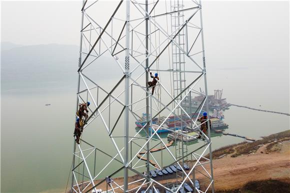 电力工人在高塔上施工作业。通讯员 杨安东 摄