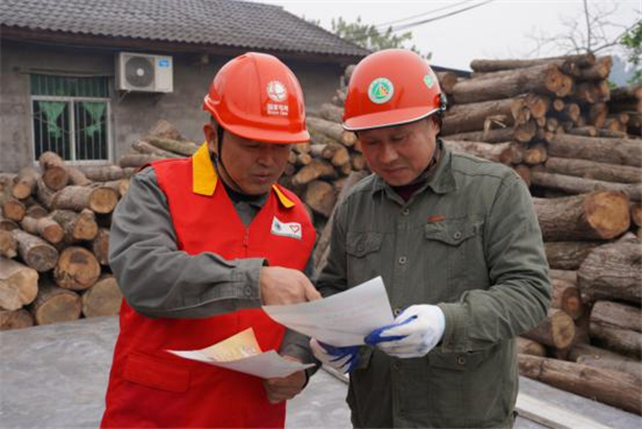 电网员工为木材加工厂负责人科普安全用电知识。通讯员 夏朝燕 摄