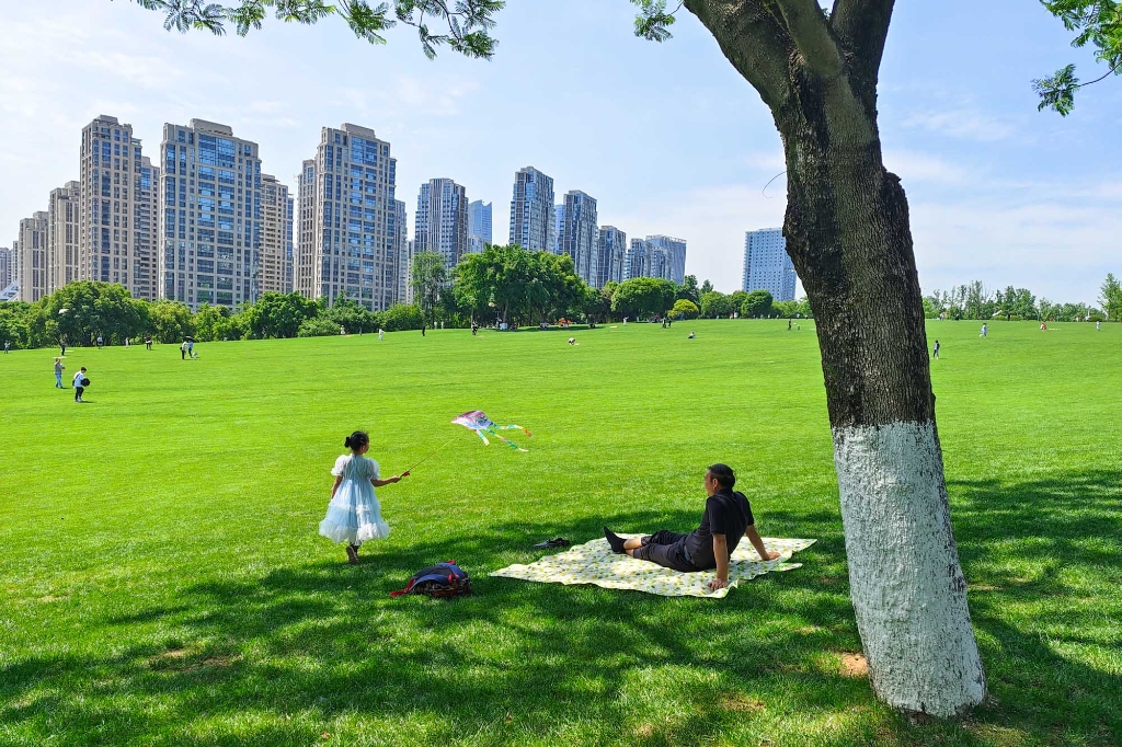 2022年5月3日，重庆中央公园，蓝天白云好天气，市民在大草坪上享受五一劳动节假期。
