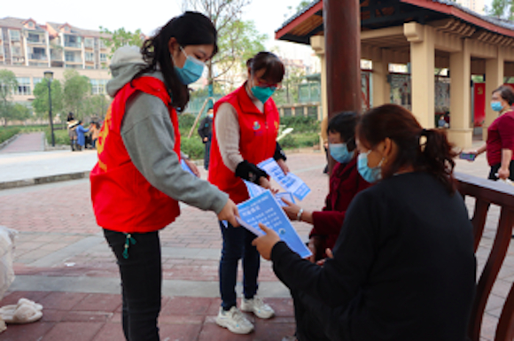 党员志愿者向群众发放宣传资料。江津区圣泉街道供图 华龙网发