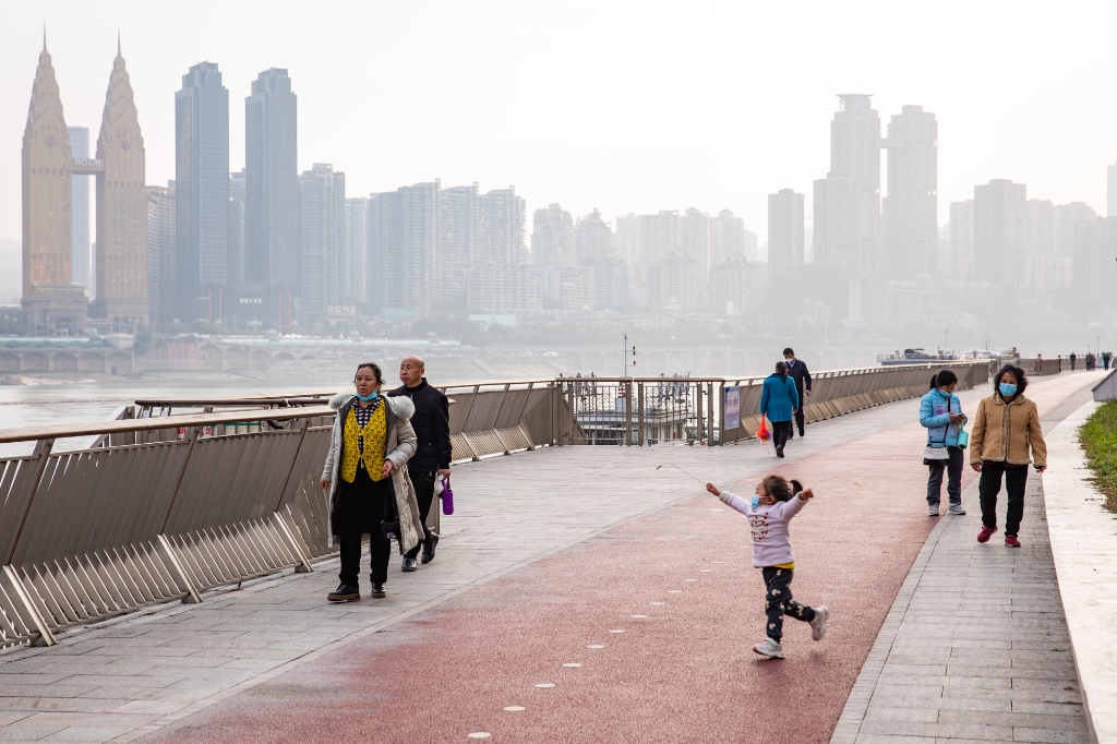 2022年12月5日，重庆市渝中区长江滨江路，人们在江边步道上散步。
